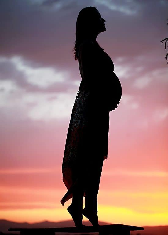 silhouette of pregnant woman at sunset