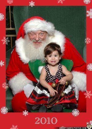 creepy santa with little girl sitting on his lap in a photo