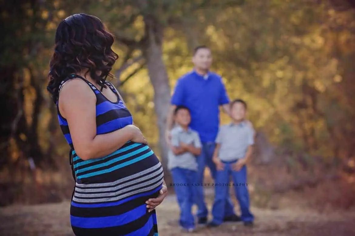 family in matching outfits pregnant woman in foreground