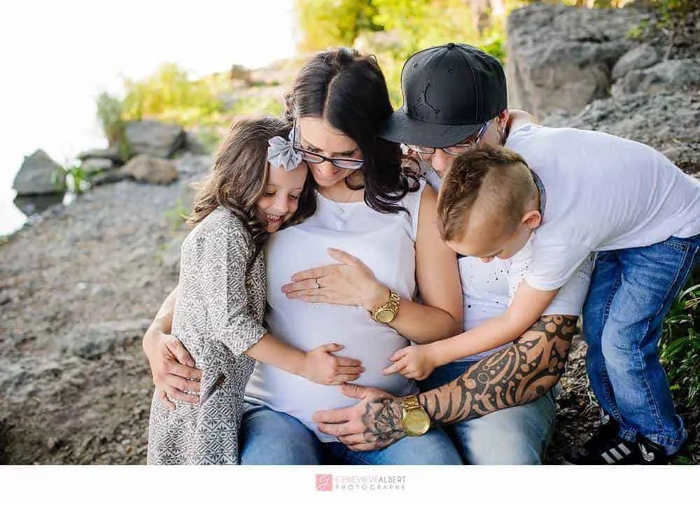gia đình ôm nhau trong buổi chụp ảnh thai sản ngoài trời