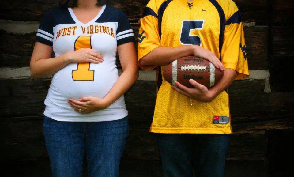 expecting couple in football jerseys for maternity portrait