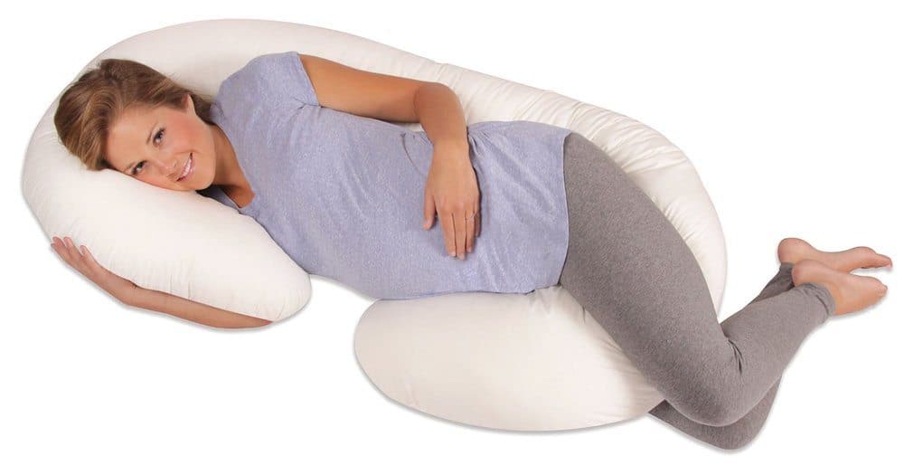 pregnant woman lying down with a maternity pillow