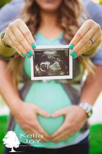 pregnant woman hold ultrasound picture in maternity portrait