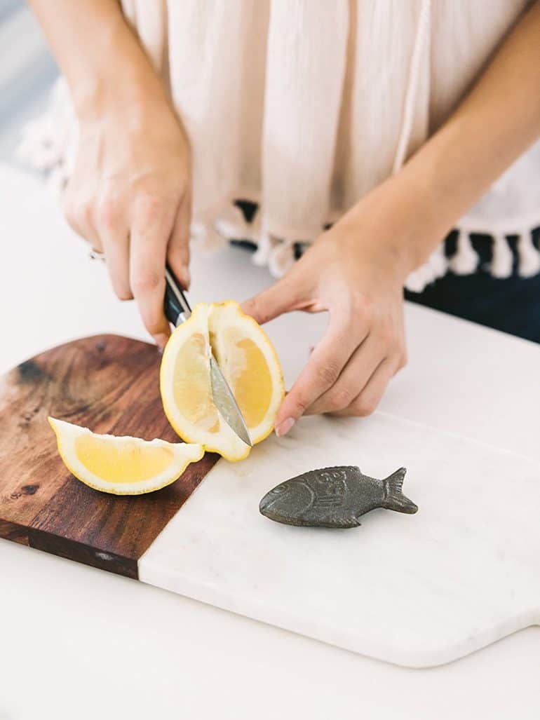 person chopping lemon next to the Lucky Iron Fish