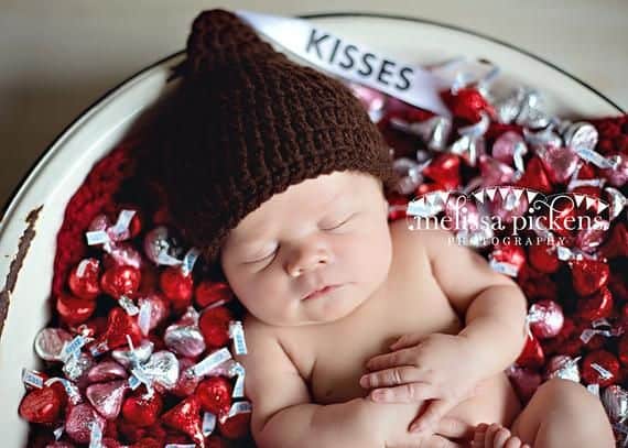 Baby sleeping in bowl of Hershey's kisses - Baby's First Valentine's Day Photo shoot