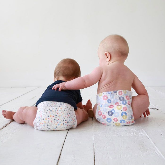 two babies sitting in abby and finn diapers