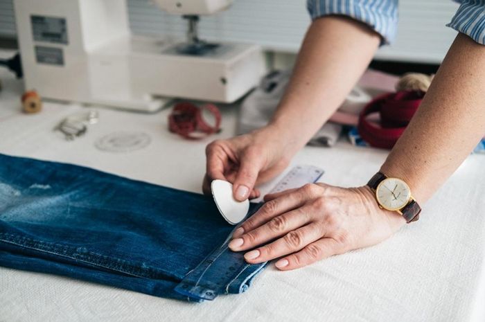 person altering the hem of jeans