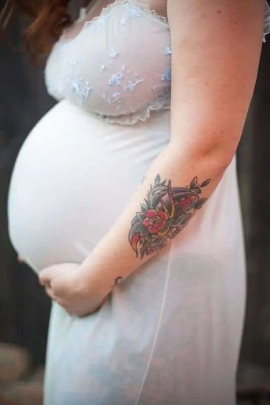 phụ nữ mang thai với hình xăm trên cánh tay