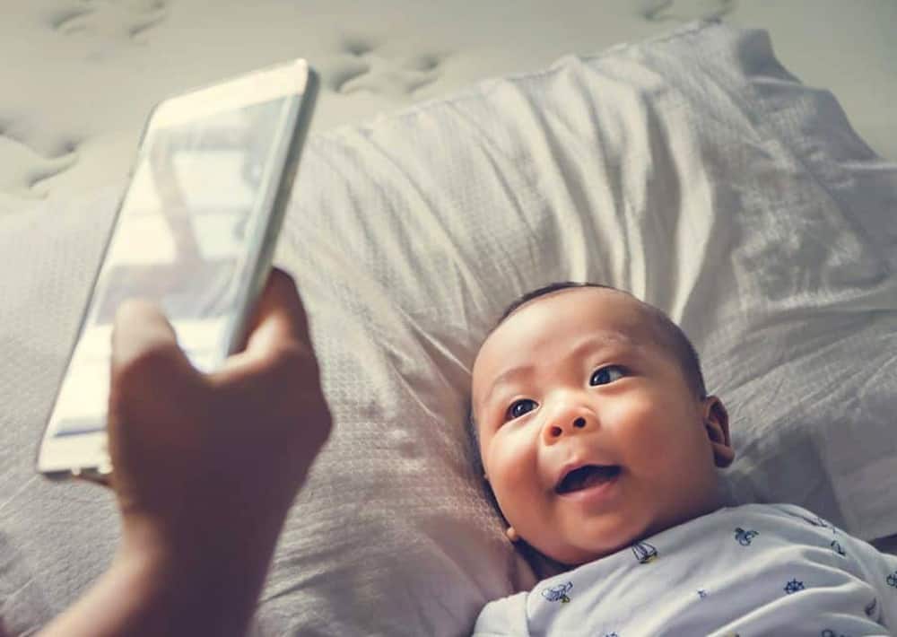 parent taking picture of baby with smart phone