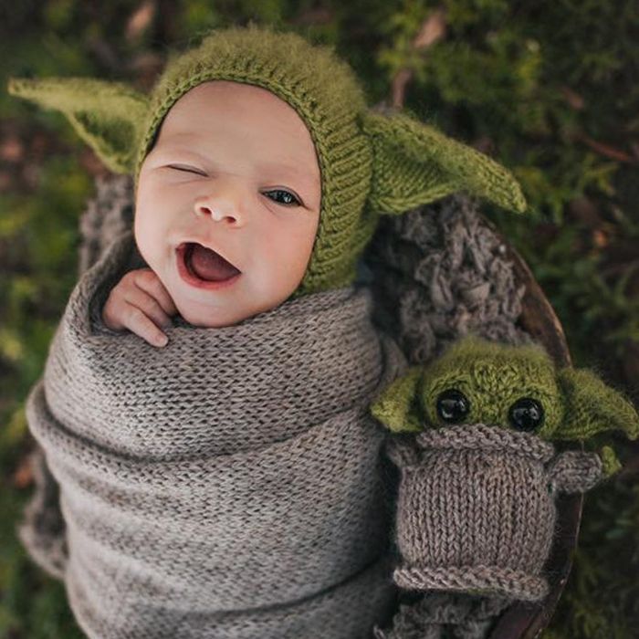 Smiling baby wearing Baby Yoda crocheted hat