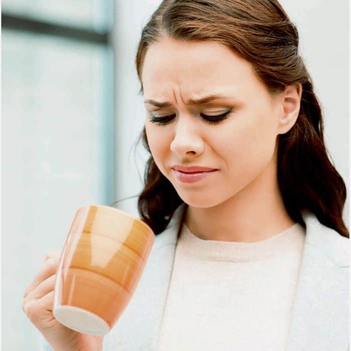 woman finds drink in mug tastes sour