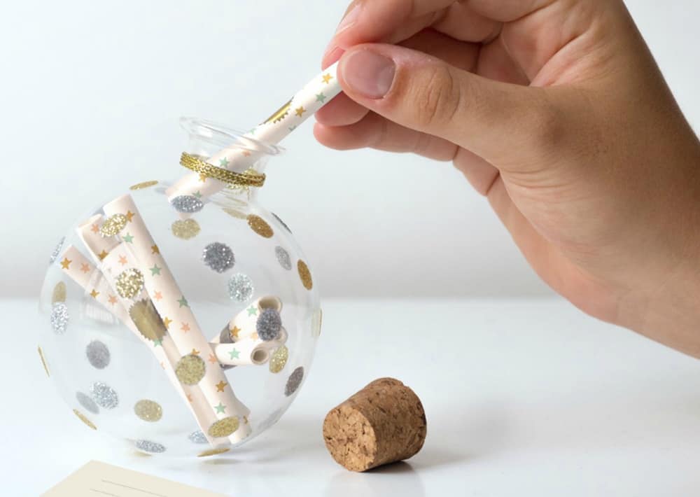 hand putting notes in baby keepsake ornament