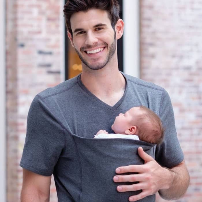 dad holding newborn baby in carrier shirt