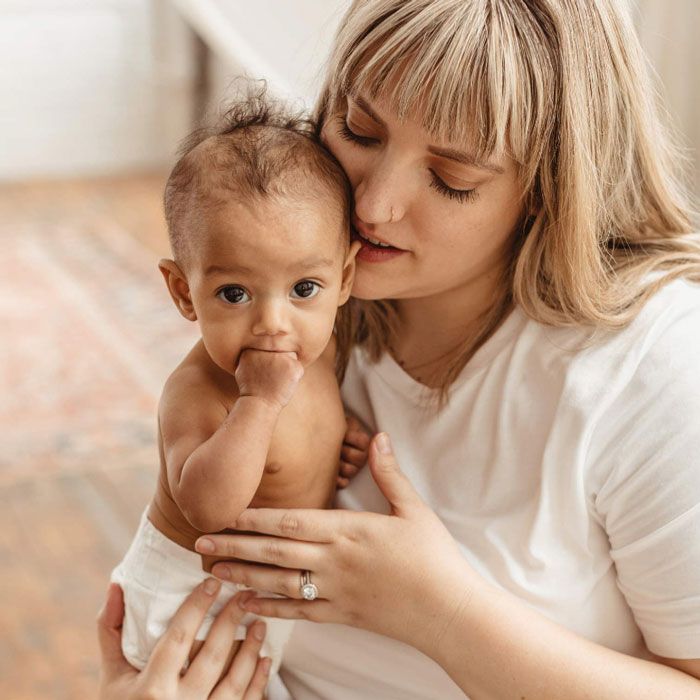 mom holding baby wearing an organic diaper made by Dyper