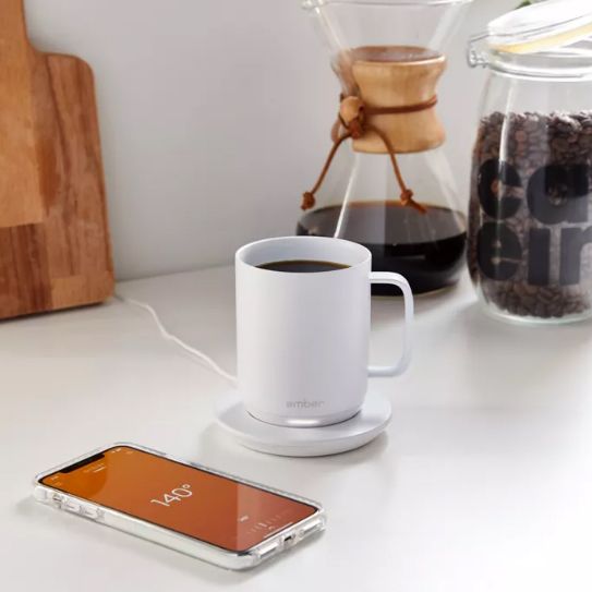 Ember Mug on counter with coffee and smart phone