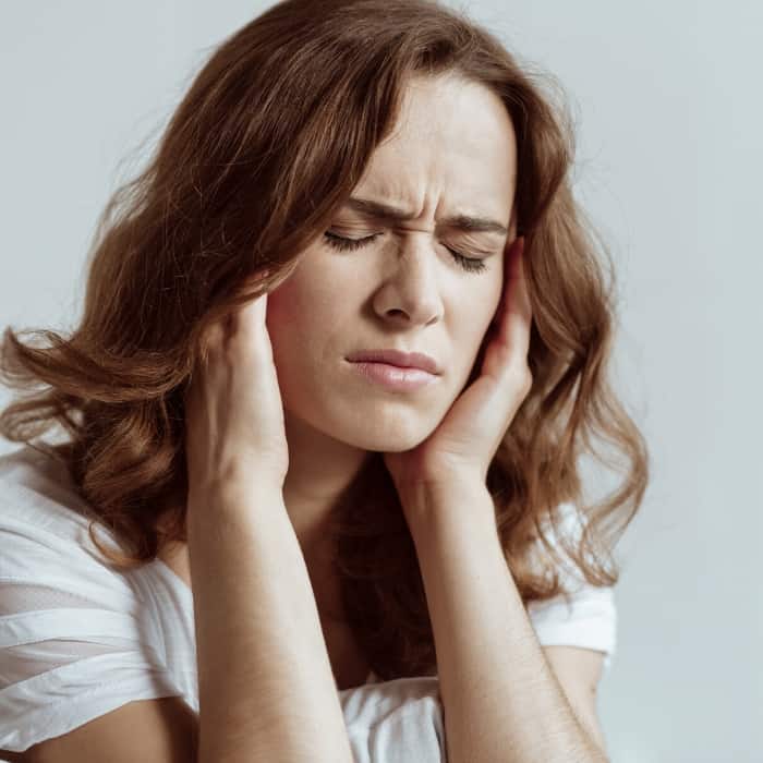 woman holding her head from a headache