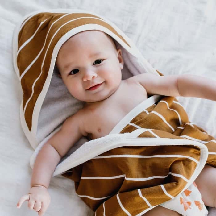 baby with brown and white striped towel