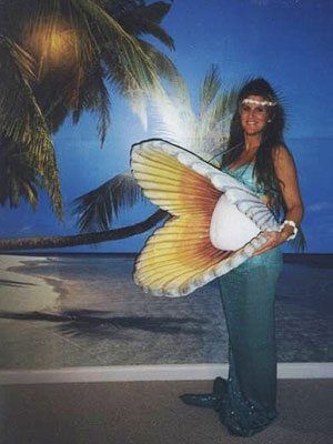 Pregnant woman dressed as mermaid with pearl belly