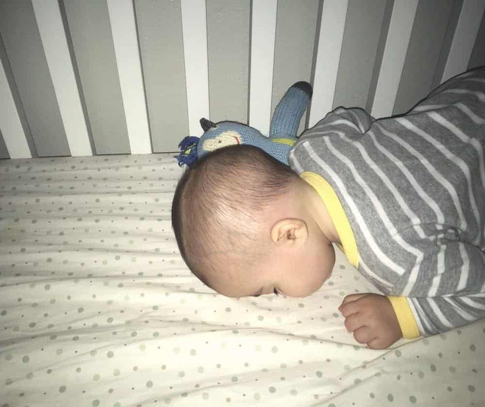 Photo of child sleeping face down in crib with nose pressed into mattress