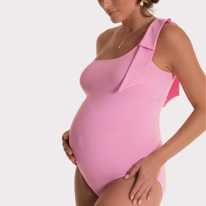 pregnant woman wearing pink one shoulder swim suit
