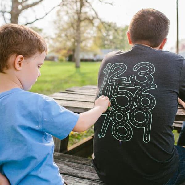 kid using car to trace numbers on his dad's T-shirt - father's day gift