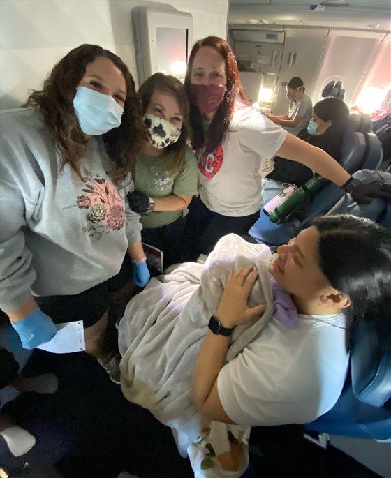 three woman with a woman who gave birth on a plane