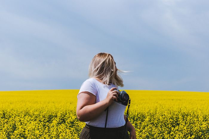 photographer in a field of yellow flowers