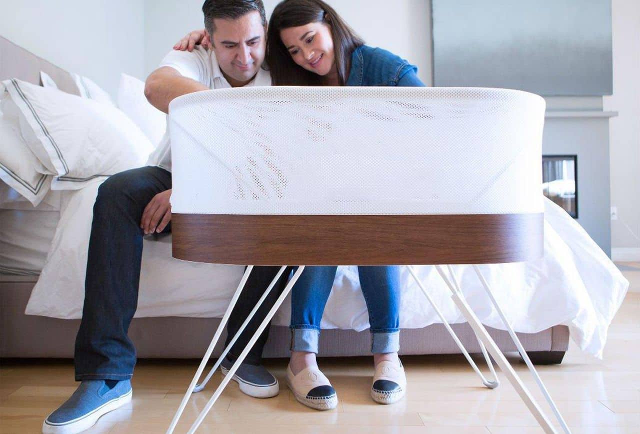 parents looking at baby in a snoo bassinet