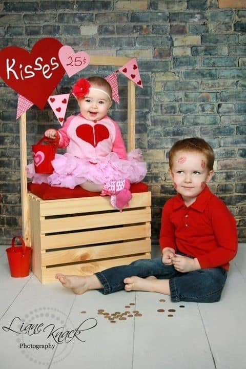 Older brother sitting next to younger sister with kiss marks on his face