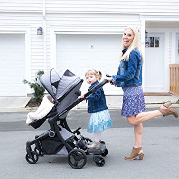 toddler riding on stroller board with mom pushing stroller