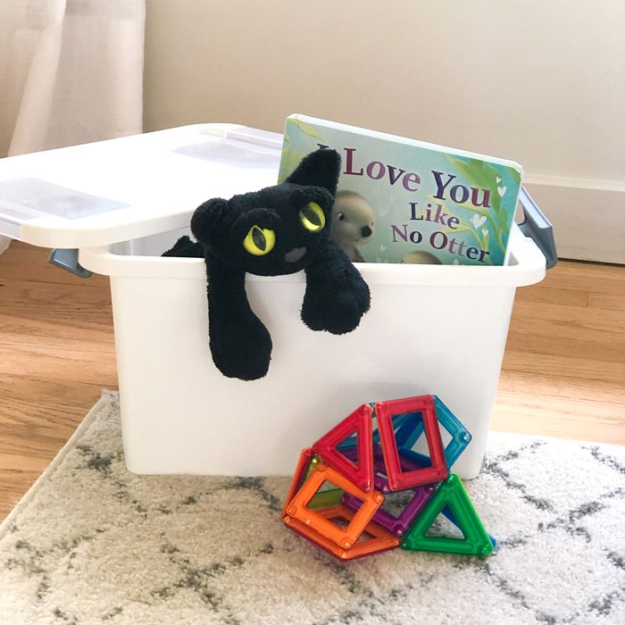 quiet activity box filled with stuffed animal, book and toys for occupying a toddler when you have a newborn