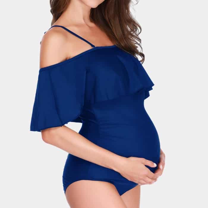 woman in her second trimester wearing blue maternity swimsuit