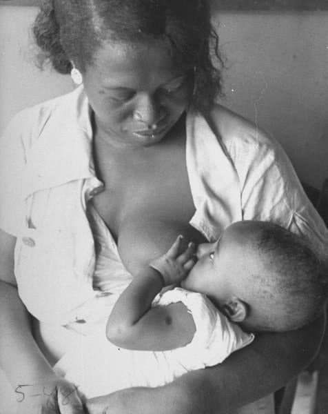 Black and white photograph of mother breastfeeding baby