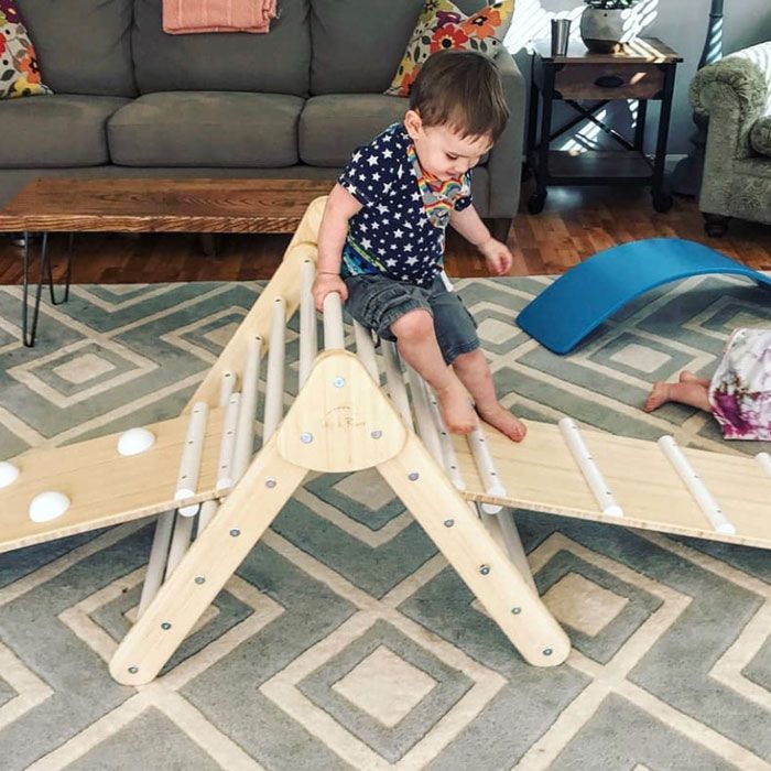 baby climbing on Pikler triangle