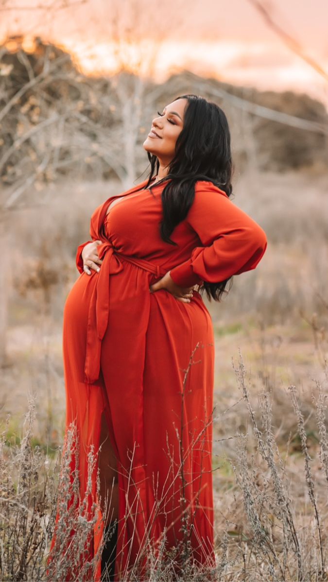 người phụ nữ mang thai mặc áo choàng đỏ chụp ảnh thai ngoài trời