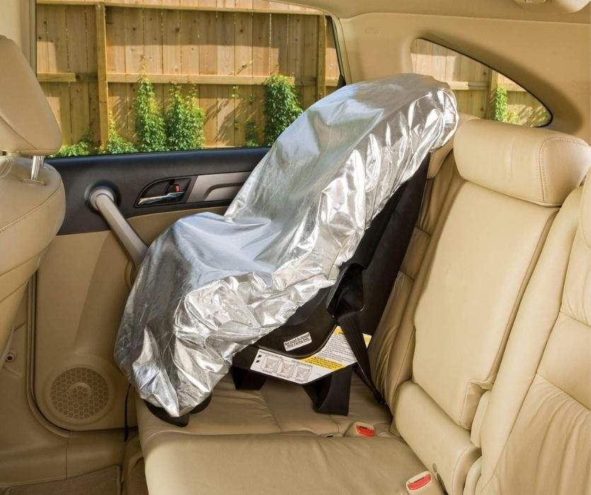 Interior of car showing car seat covered in foil-like car seat sun shade cover