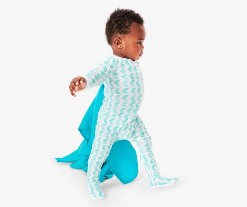baby walking with blue blanket and zip up pajamas from primary