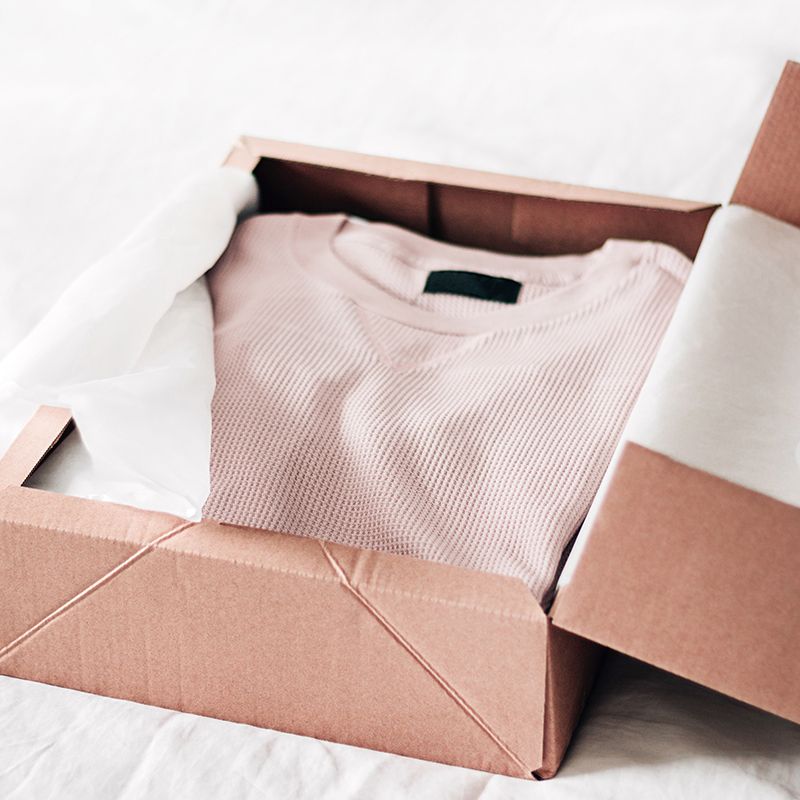 Bird Style box opened with light pink waffle textured shirt folded neatly
