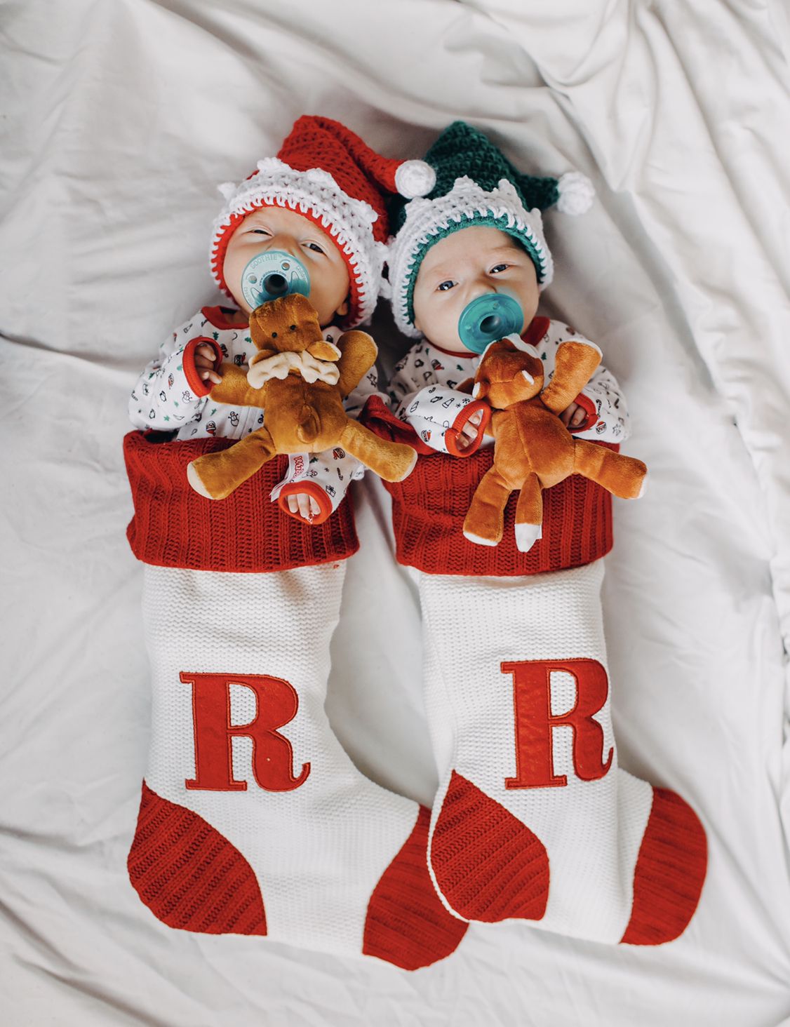 twin babies in christmas stocking with moose pacifiers