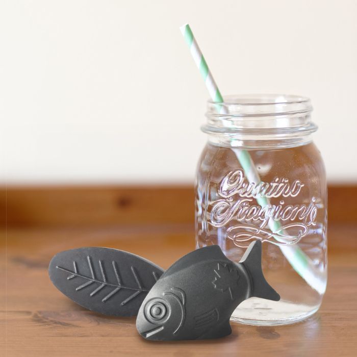 lucky iron fish and leaf next to jar of water with straw