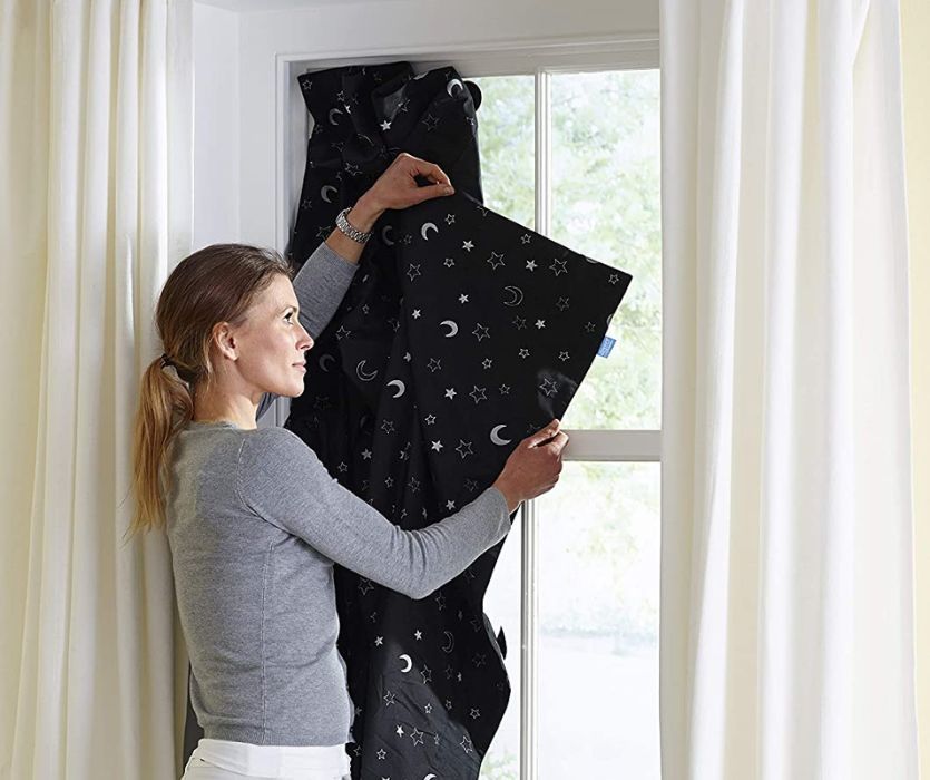 woman hanging up a Gro-Anywhere blind in a window