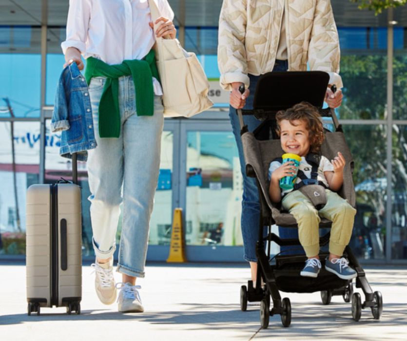 two women travelling pushing a child in a Sparrow compact stroller