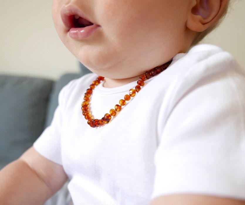 close up of baby with an amber teething necklace