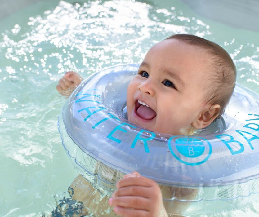 baby in pool with flotation ring around their neck
