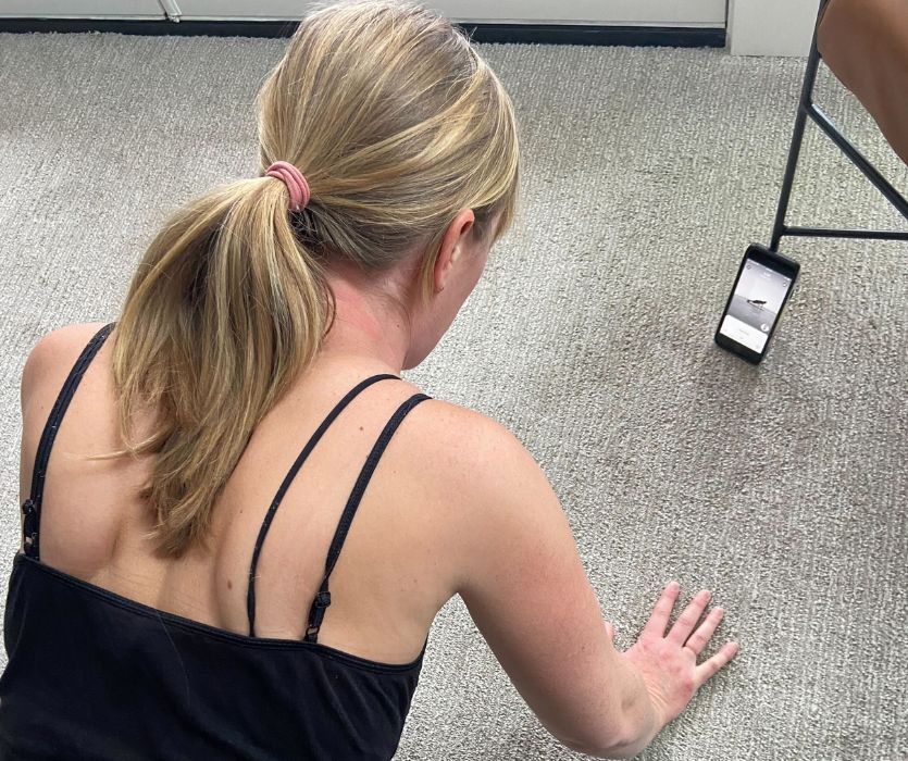 Female looking at phone while in plank position 