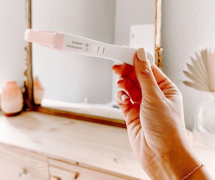 hand holding a positive First Response Early Result pregnancy test
