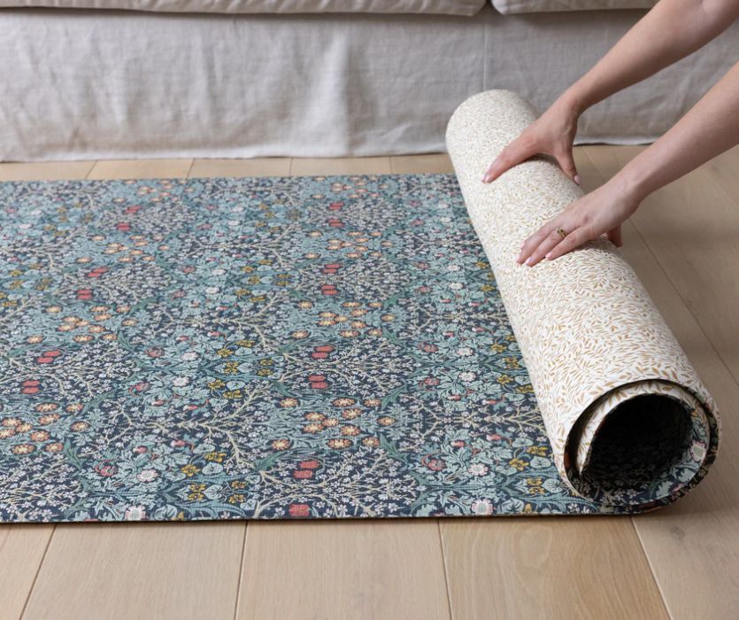 woman rolling up a Totter + Tumble Play Mat