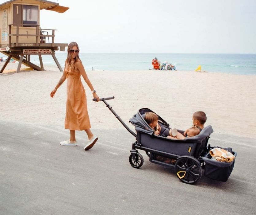 mom pulling kids in a veer wagon on the beach