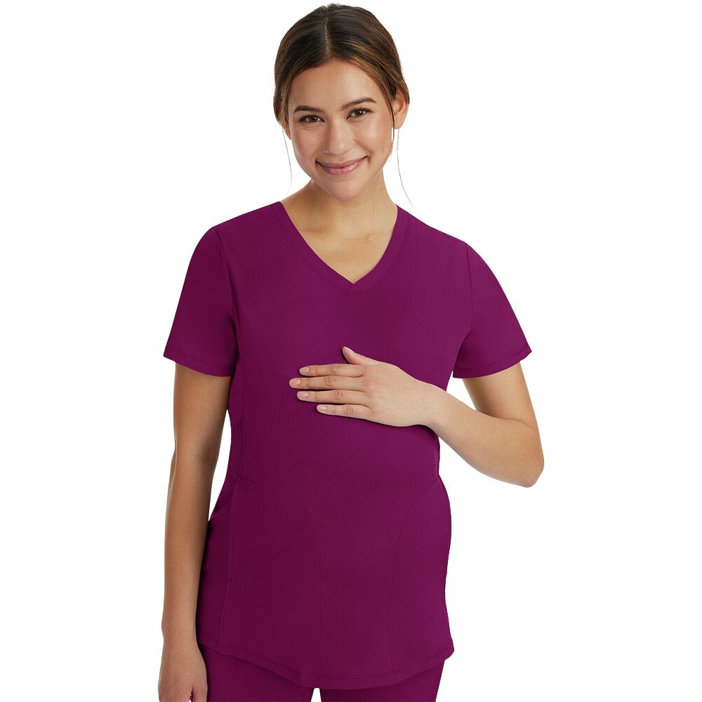 woman resting her hand on her pregnant belly wearing purple scrubs
