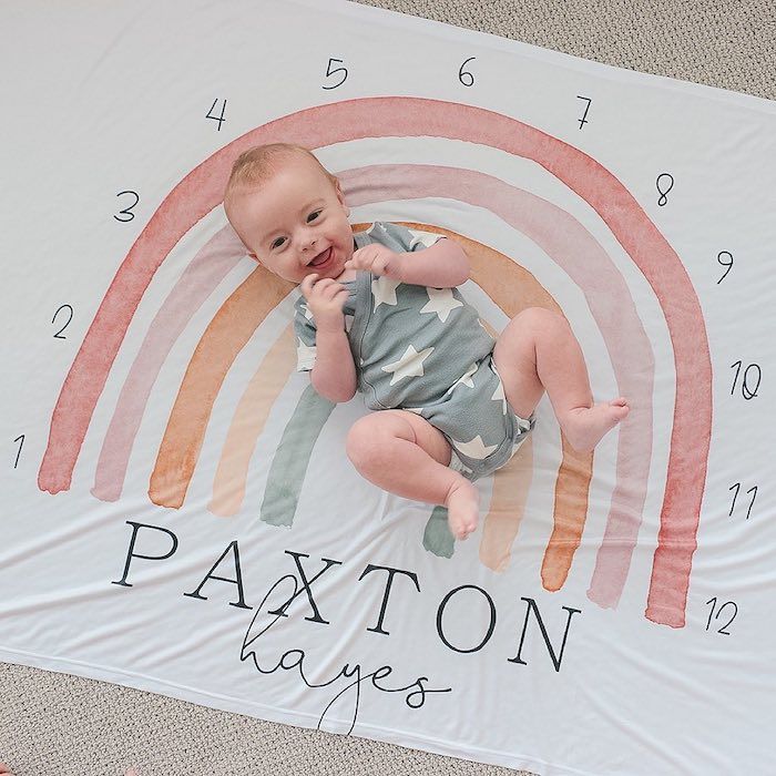 baby lying on milestone rainbow blanket